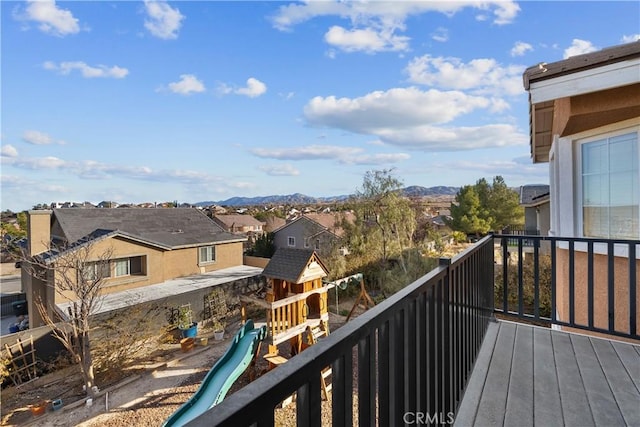 wooden terrace with a playground and a mountain view