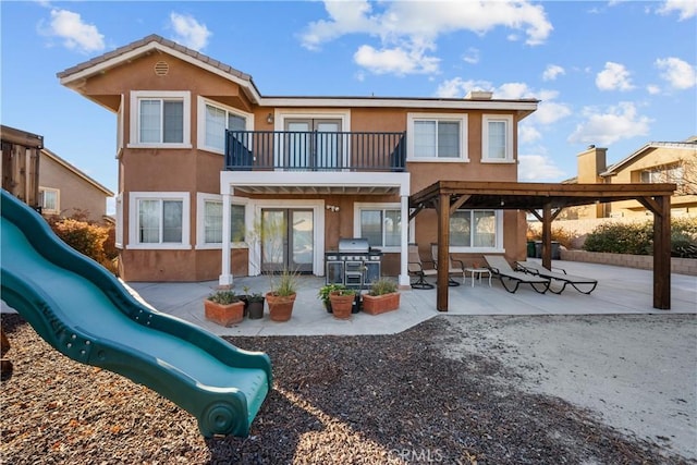 back of house featuring a patio area and a balcony