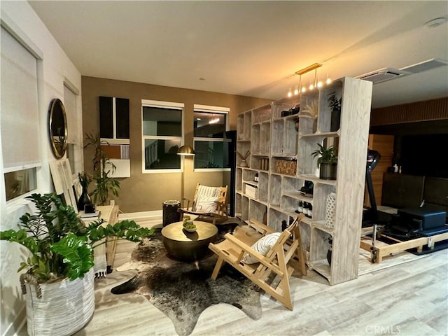 sitting room with hardwood / wood-style flooring, track lighting, and an inviting chandelier