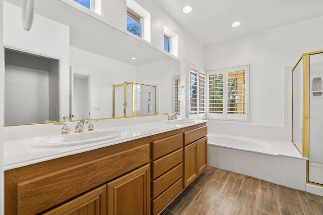 bathroom featuring hardwood / wood-style floors, vanity, and shower with separate bathtub