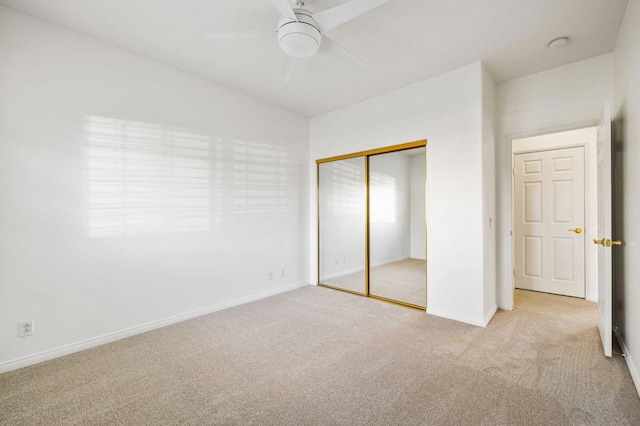 unfurnished bedroom with ceiling fan, a closet, and light colored carpet