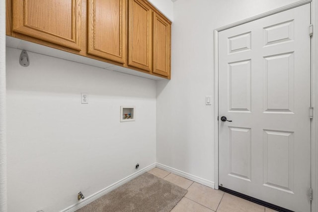 laundry room with light tile patterned floors, cabinets, and washer hookup