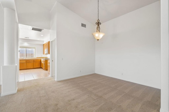 carpeted empty room with high vaulted ceiling