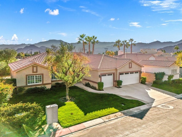 mediterranean / spanish home with a mountain view, a garage, and a front yard