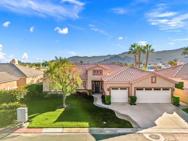 mediterranean / spanish-style home with a mountain view, a front yard, and a garage