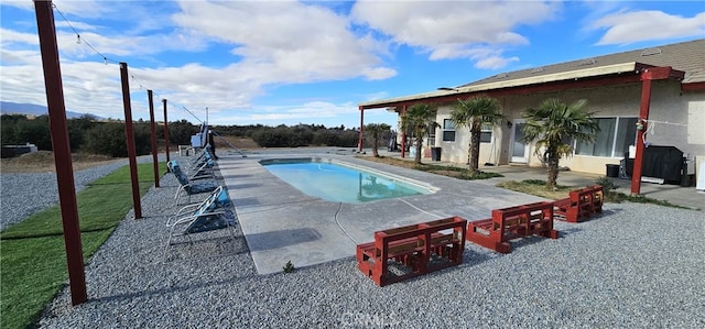 view of swimming pool featuring a patio area and a yard