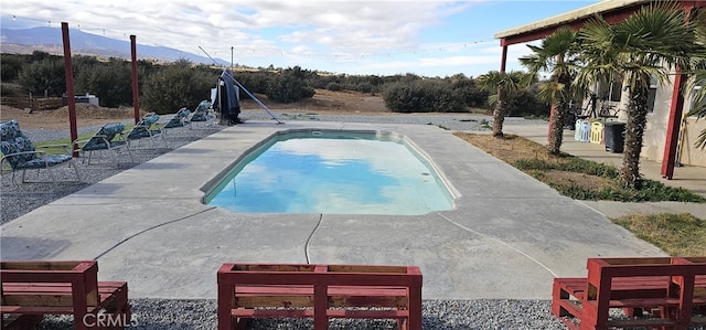 view of pool featuring a mountain view and a patio area