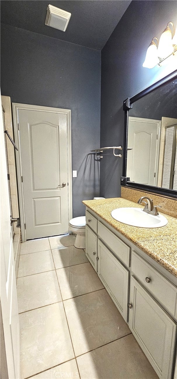 bathroom featuring toilet, vanity, and tile patterned floors