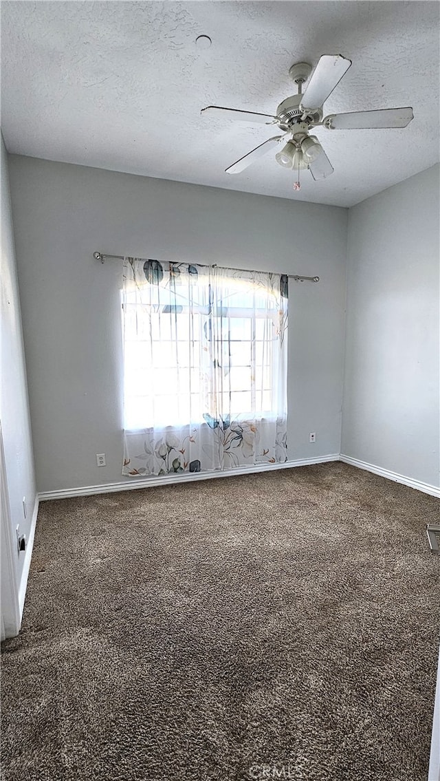 carpeted empty room featuring ceiling fan and a textured ceiling