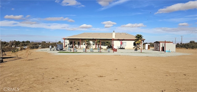 rear view of house featuring a shed