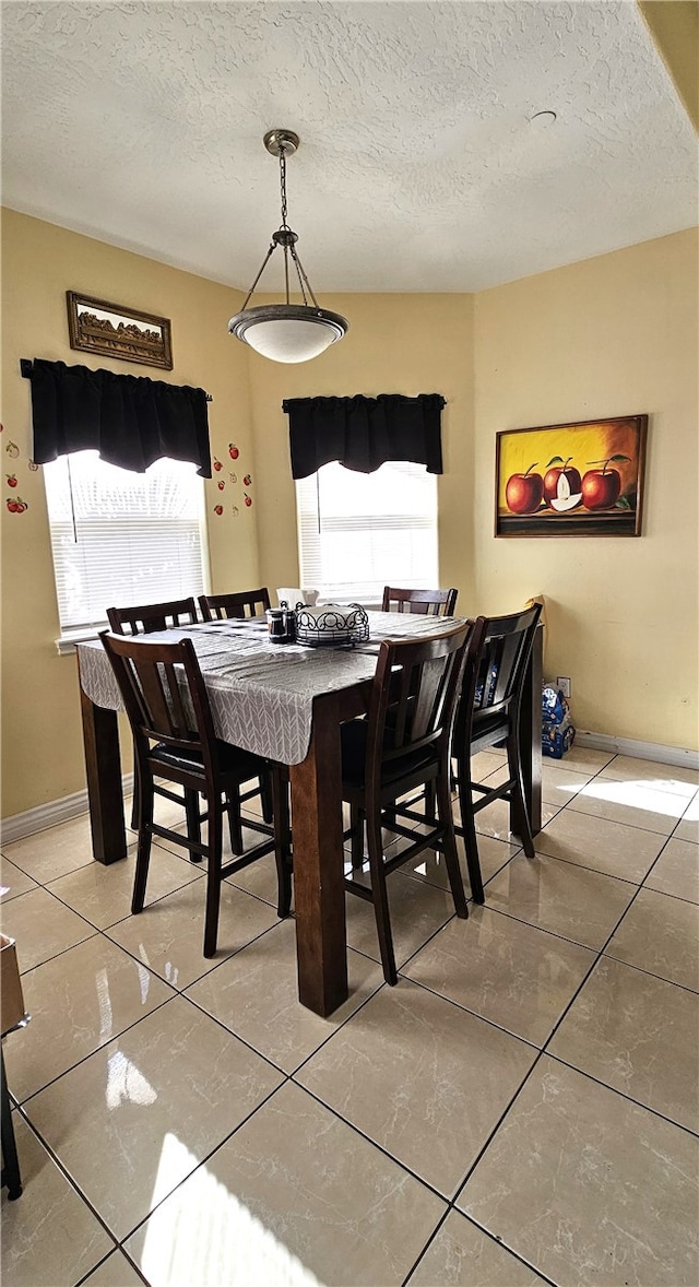 dining area featuring tile patterned flooring and a textured ceiling