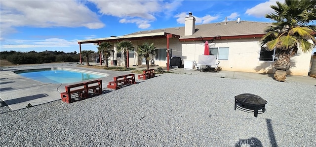 rear view of house with an outdoor fire pit and a patio area