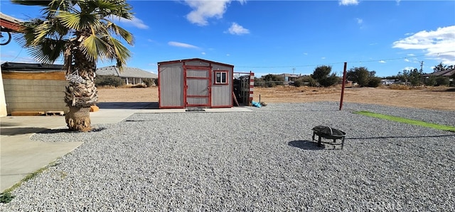 view of play area featuring a fire pit and a storage unit