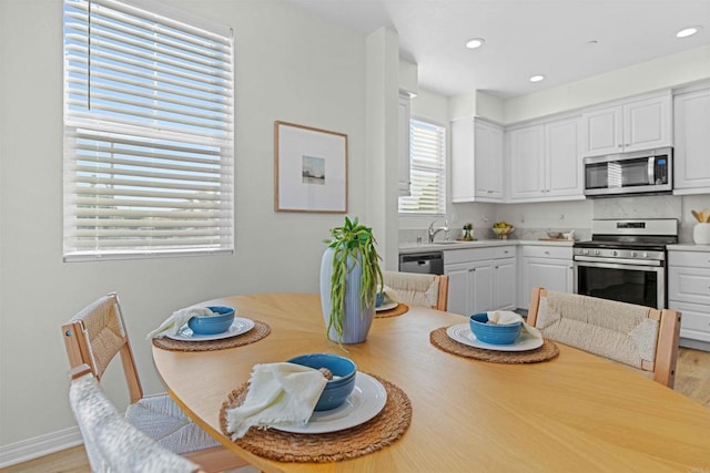 dining area with light hardwood / wood-style floors and sink