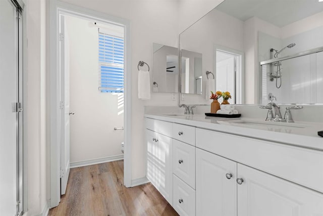 bathroom with wood-type flooring, toilet, an enclosed shower, and vanity