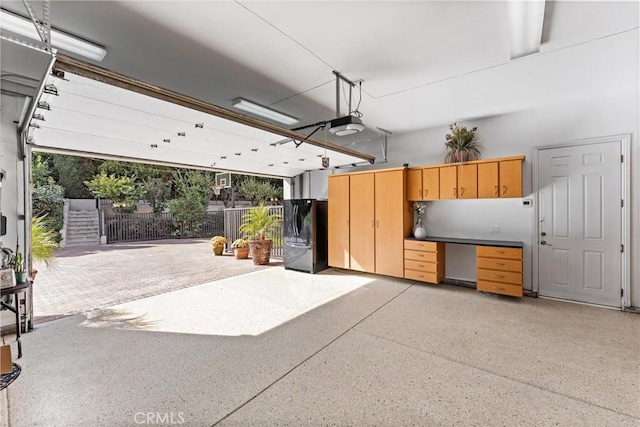 garage with black fridge and a garage door opener