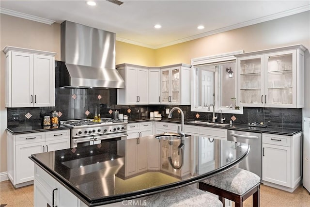 kitchen with crown molding, sink, wall chimney exhaust hood, appliances with stainless steel finishes, and tasteful backsplash