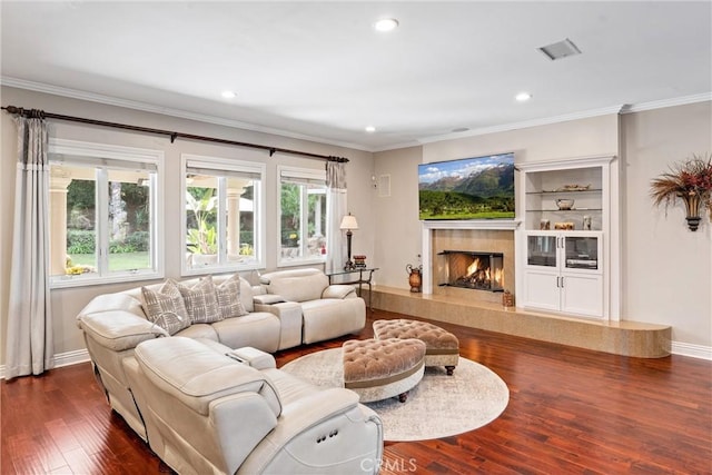 living room featuring a premium fireplace, dark wood-type flooring, and ornamental molding