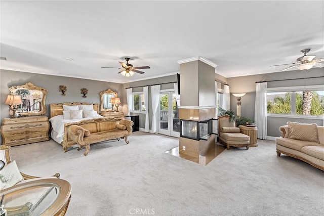 bedroom featuring ceiling fan, access to exterior, crown molding, and multiple windows