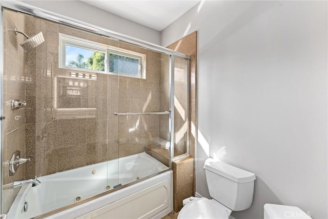 bathroom featuring combined bath / shower with glass door and toilet