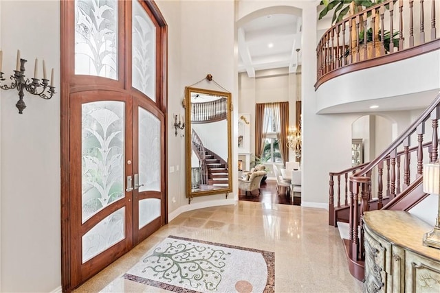 entrance foyer featuring beam ceiling, french doors, and a high ceiling