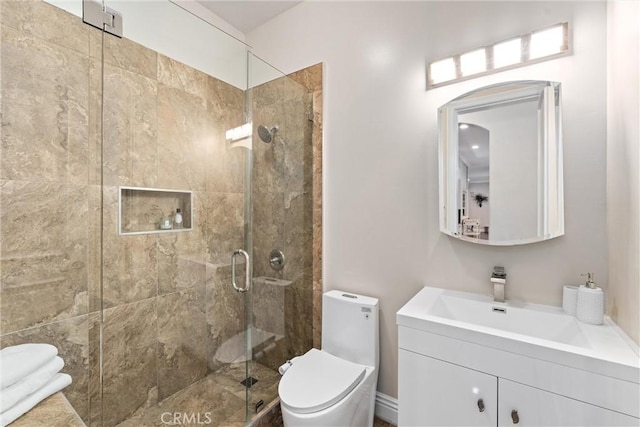 bathroom featuring vanity, toilet, and a shower with shower door