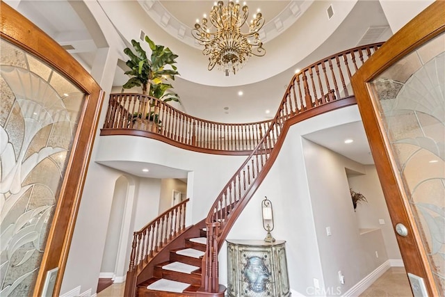 stairs featuring a towering ceiling and a chandelier