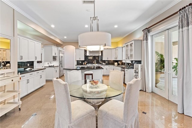 dining space featuring sink and crown molding