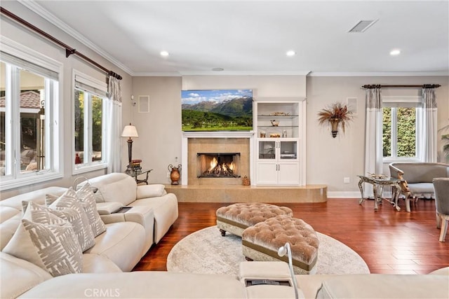 living room with dark hardwood / wood-style flooring, ornamental molding, and a wealth of natural light