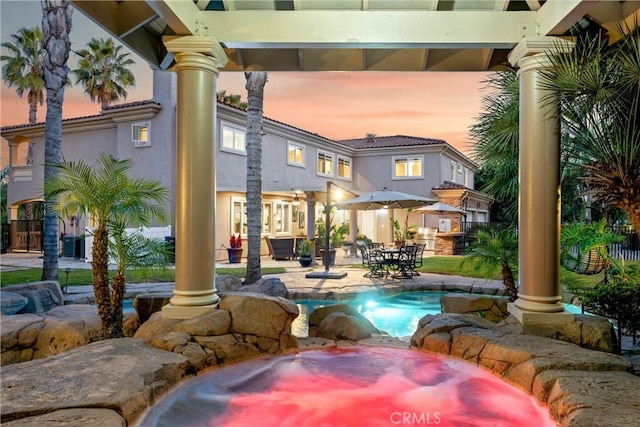 pool at dusk featuring a patio area