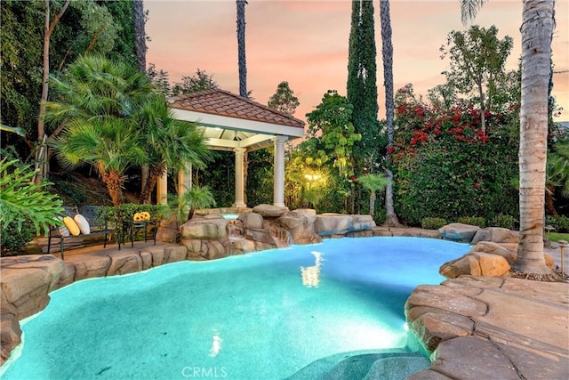 pool at dusk with a gazebo