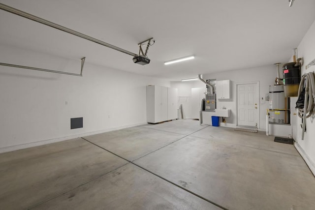 garage with strapped water heater, a garage door opener, and heating unit