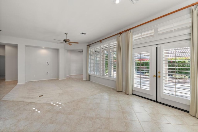 empty room with ceiling fan, light tile patterned floors, and french doors