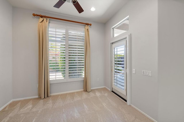 doorway with ceiling fan and light colored carpet