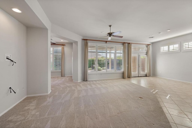 spare room with ceiling fan and light tile patterned flooring