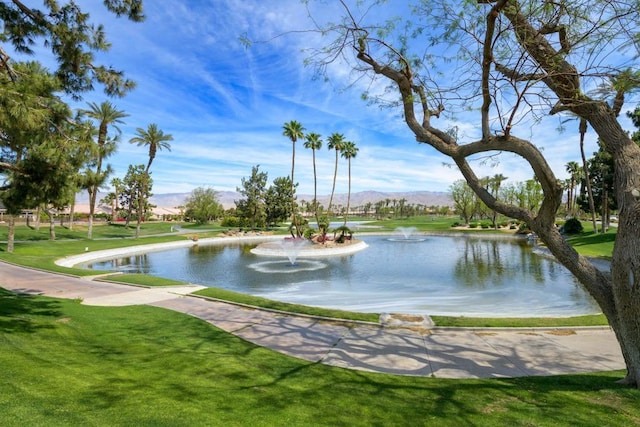 view of property's community featuring a yard and a water and mountain view