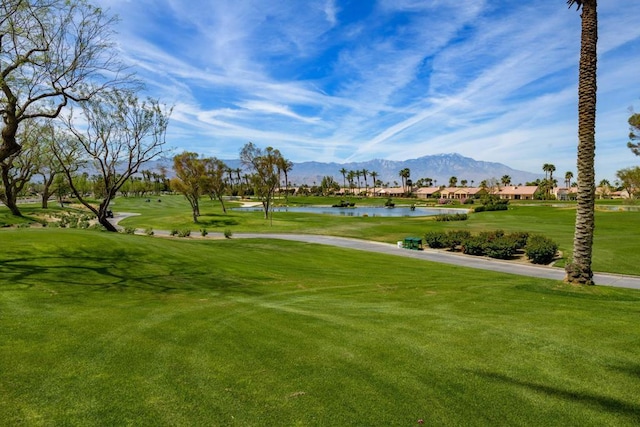 view of property's community featuring a yard and a water and mountain view