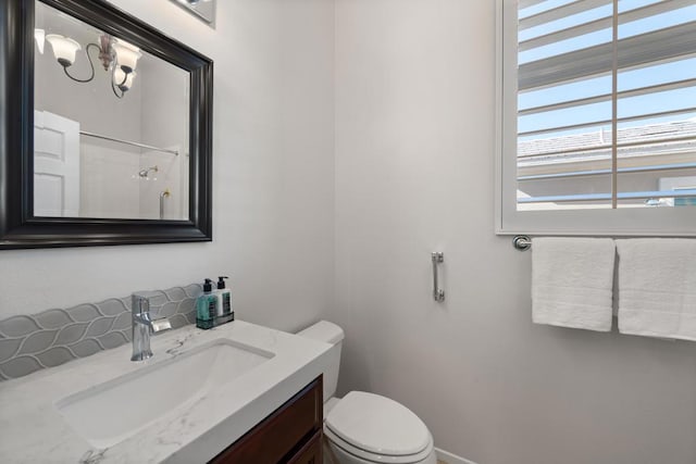 bathroom with a shower, vanity, and toilet