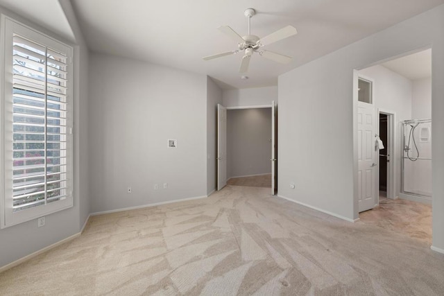 unfurnished bedroom featuring ceiling fan, light carpet, and a spacious closet