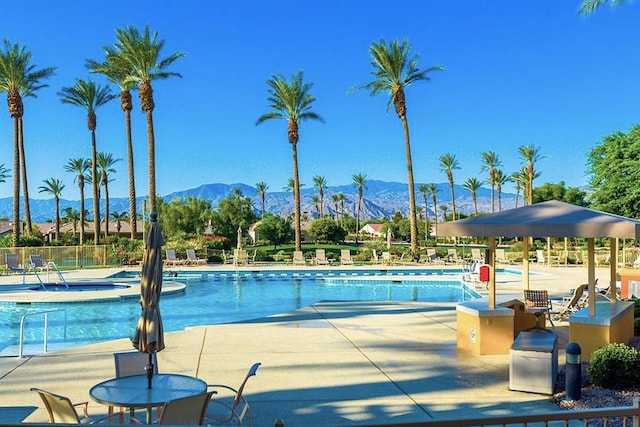 view of swimming pool with a mountain view and a patio area