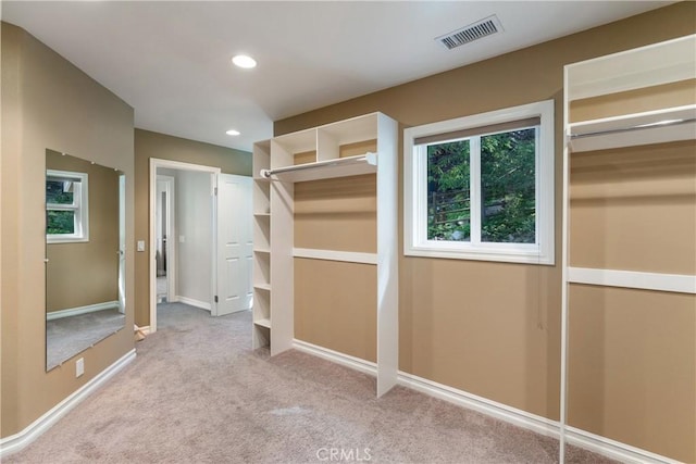 walk in closet featuring light carpet