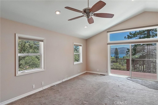 spare room featuring carpet flooring, ceiling fan, a healthy amount of sunlight, and lofted ceiling