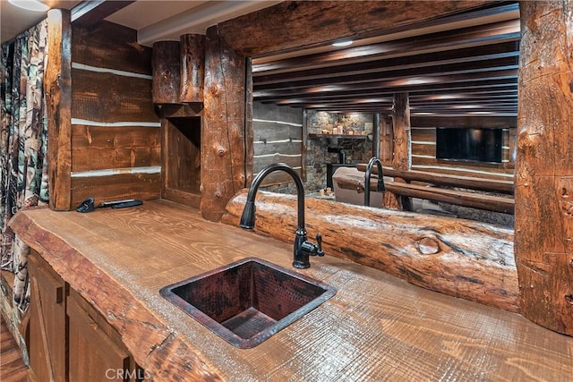 kitchen featuring beam ceiling and sink