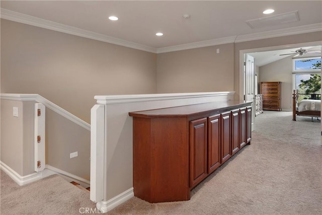 corridor with lofted ceiling, light colored carpet, and ornamental molding