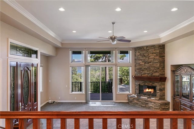 unfurnished living room with carpet flooring, crown molding, a fireplace, and ceiling fan