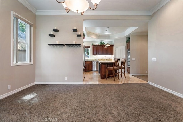 kitchen featuring a breakfast bar, light carpet, appliances with stainless steel finishes, a kitchen island, and a chandelier