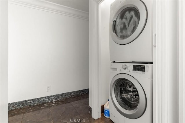 washroom featuring stacked washing maching and dryer and ornamental molding