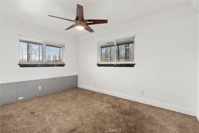 carpeted empty room with a wealth of natural light, crown molding, and ceiling fan