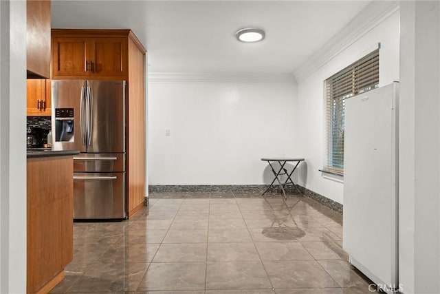 kitchen with stainless steel fridge with ice dispenser, white refrigerator, and ornamental molding