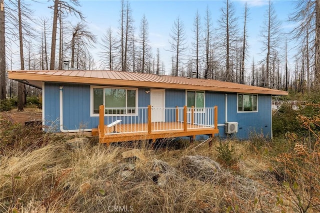 view of front of property with a wall unit AC and a wooden deck